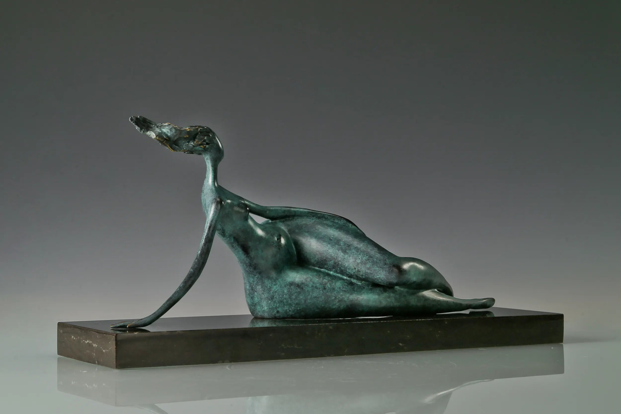 Profile of green patina bronze woman sculpture resting on her side