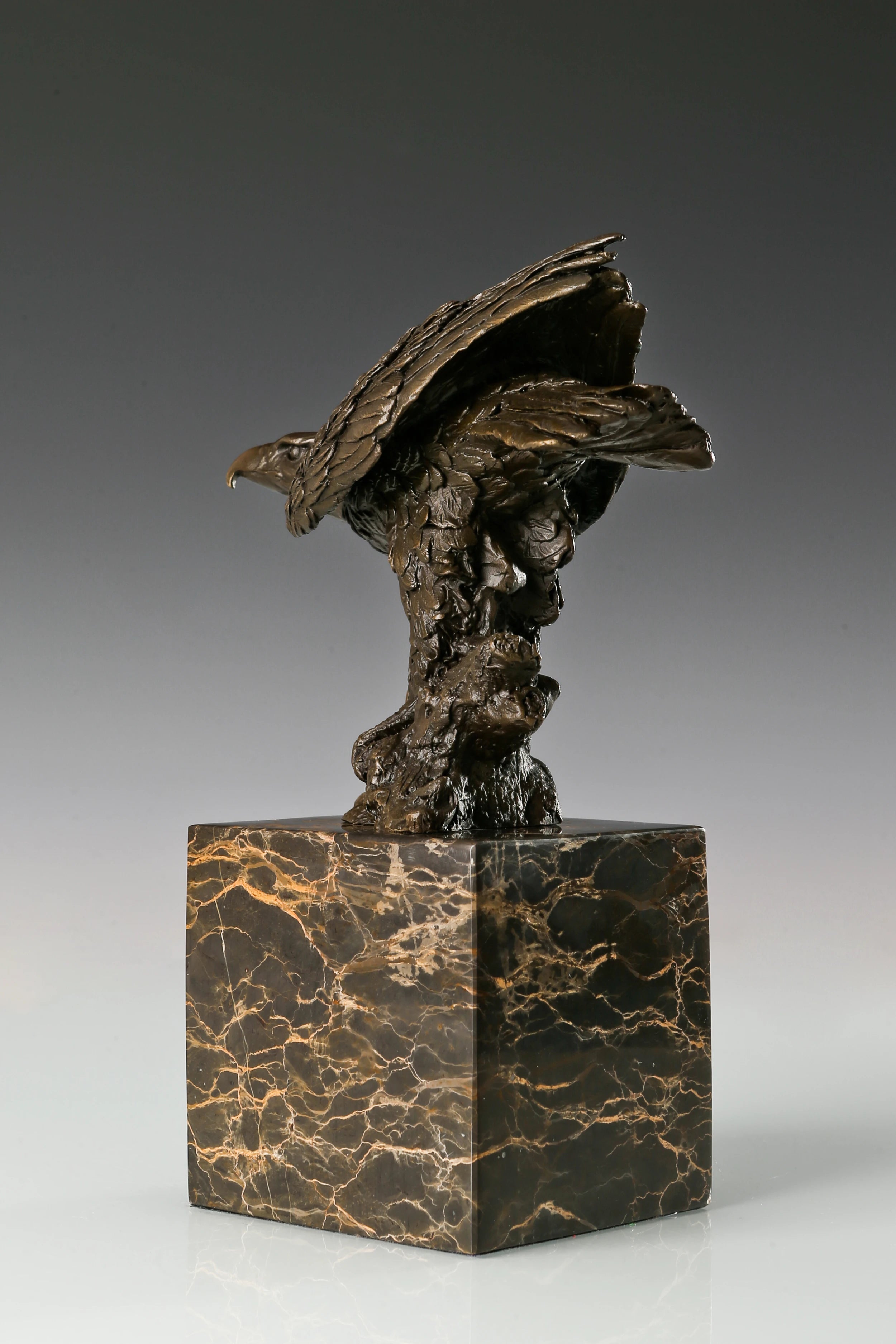 Bronze eagle sculpture ready to fly with wings partially spread and marble base. A powerful symbol of strength, freedom, and ambition.