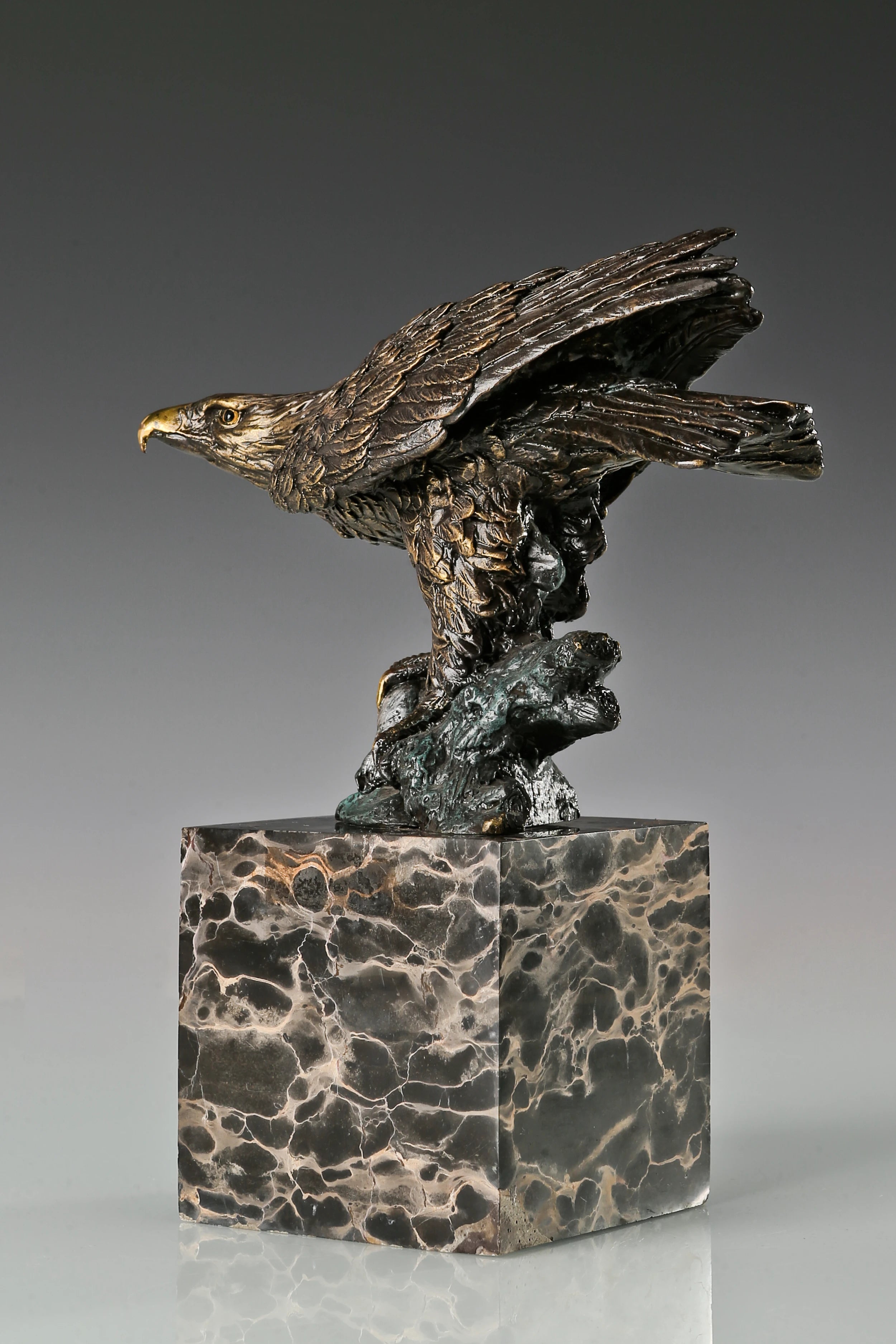 Bronze eagle sculpture ready to fly with wings partially spread and marble base. A powerful symbol of strength, freedom, and ambition.