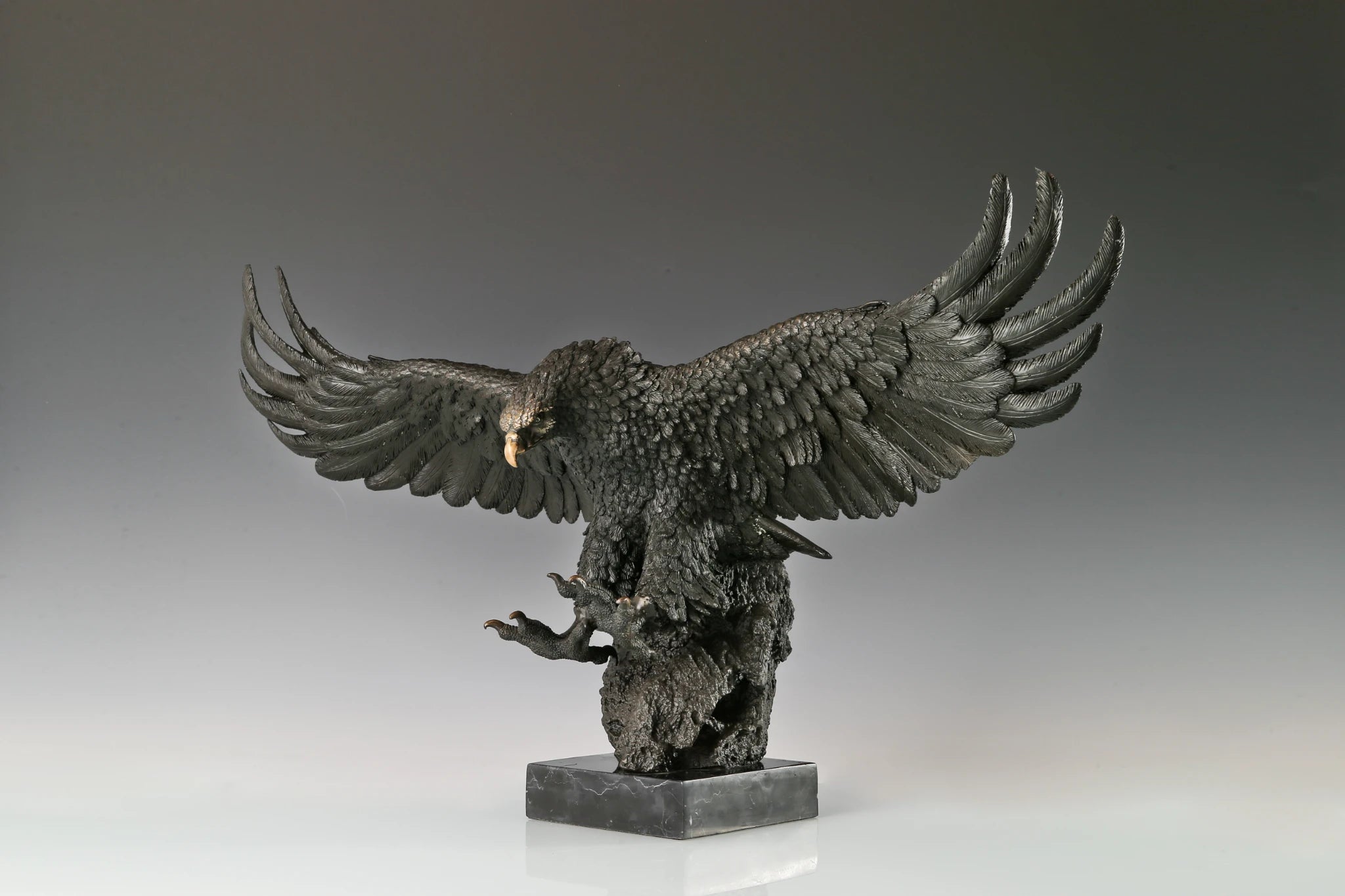 Majestic bald eagle bronze sculpture with wings spread and talons extended. A powerful wildlife statue symbolizing freedom, strength, and leadership.
