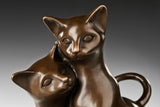 Close-up detail of two affectionate cats in bronze