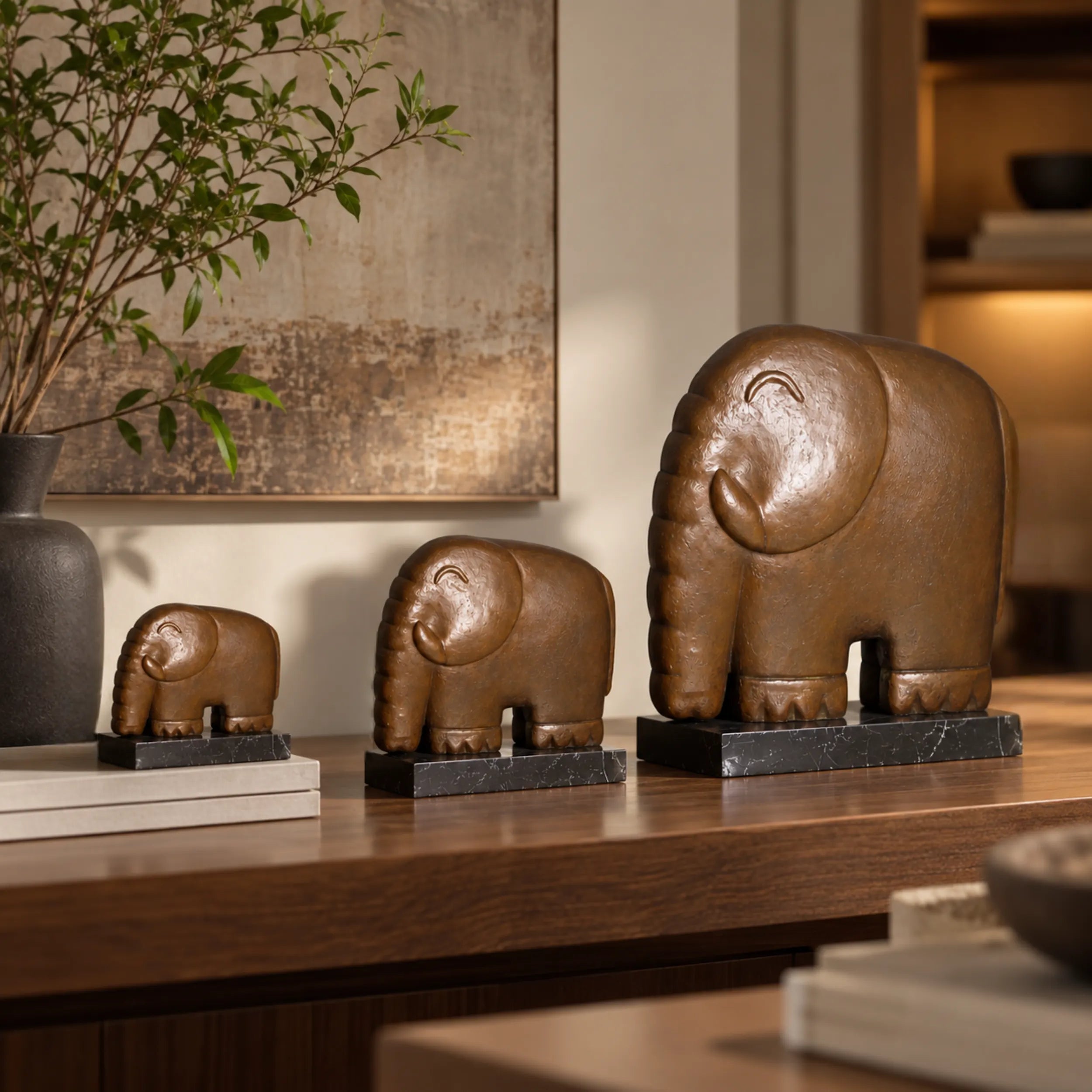 Three sizes of minimalist elephant bronze sculptures displayed in a modern interior