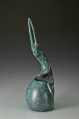 Narrow side view of modern bronze dancer sculpture with elongated curved design