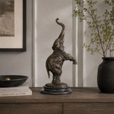A modern bronze elephant calf statue in an energetic rearing pose with trunk curled high, perfect for modern interior home decor.