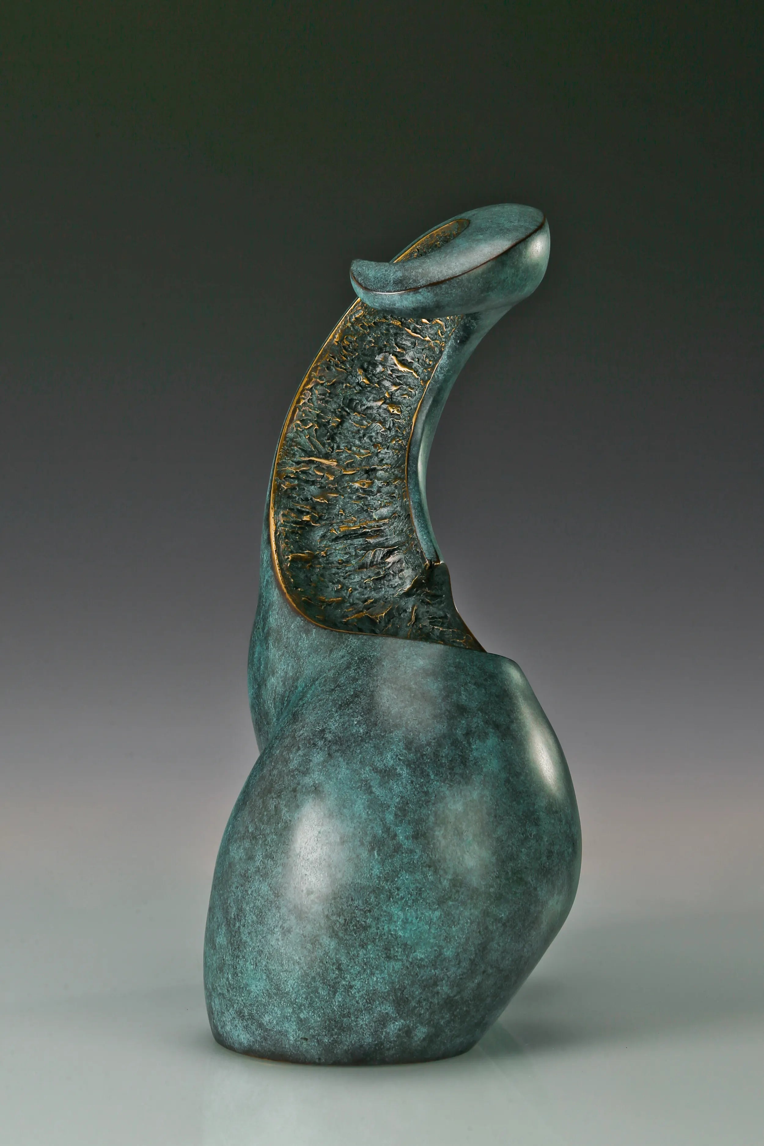 Side profile of modern female torso sculpture with green patina