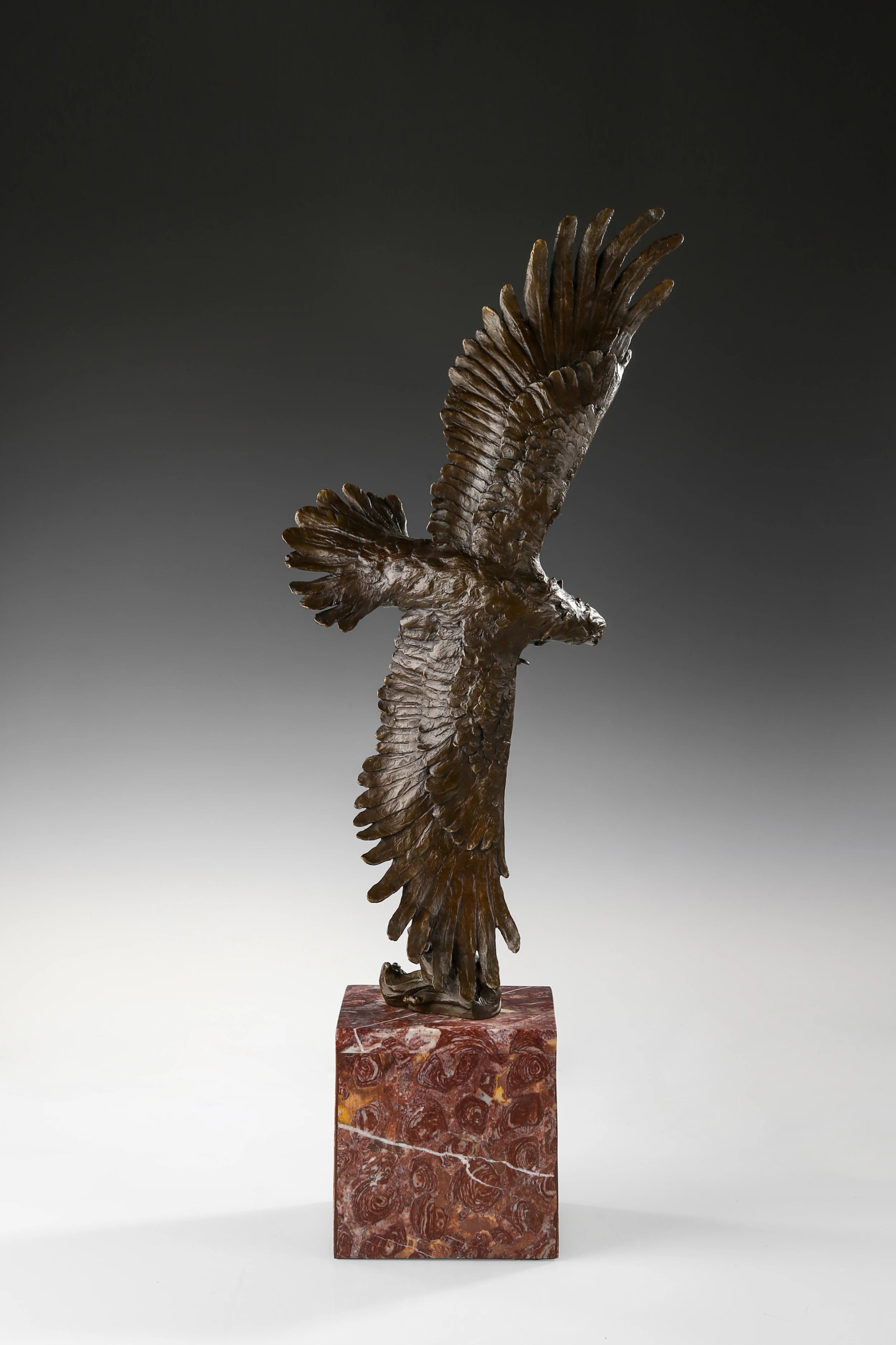 Bronze eagle sculpture over ocean waves with detailed feathers and marble base. Unique wildlife statue for home decor and collectors.