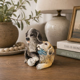 Playful bronze puppy pair sculpture with toys displayed as cheerful home and shelf decor