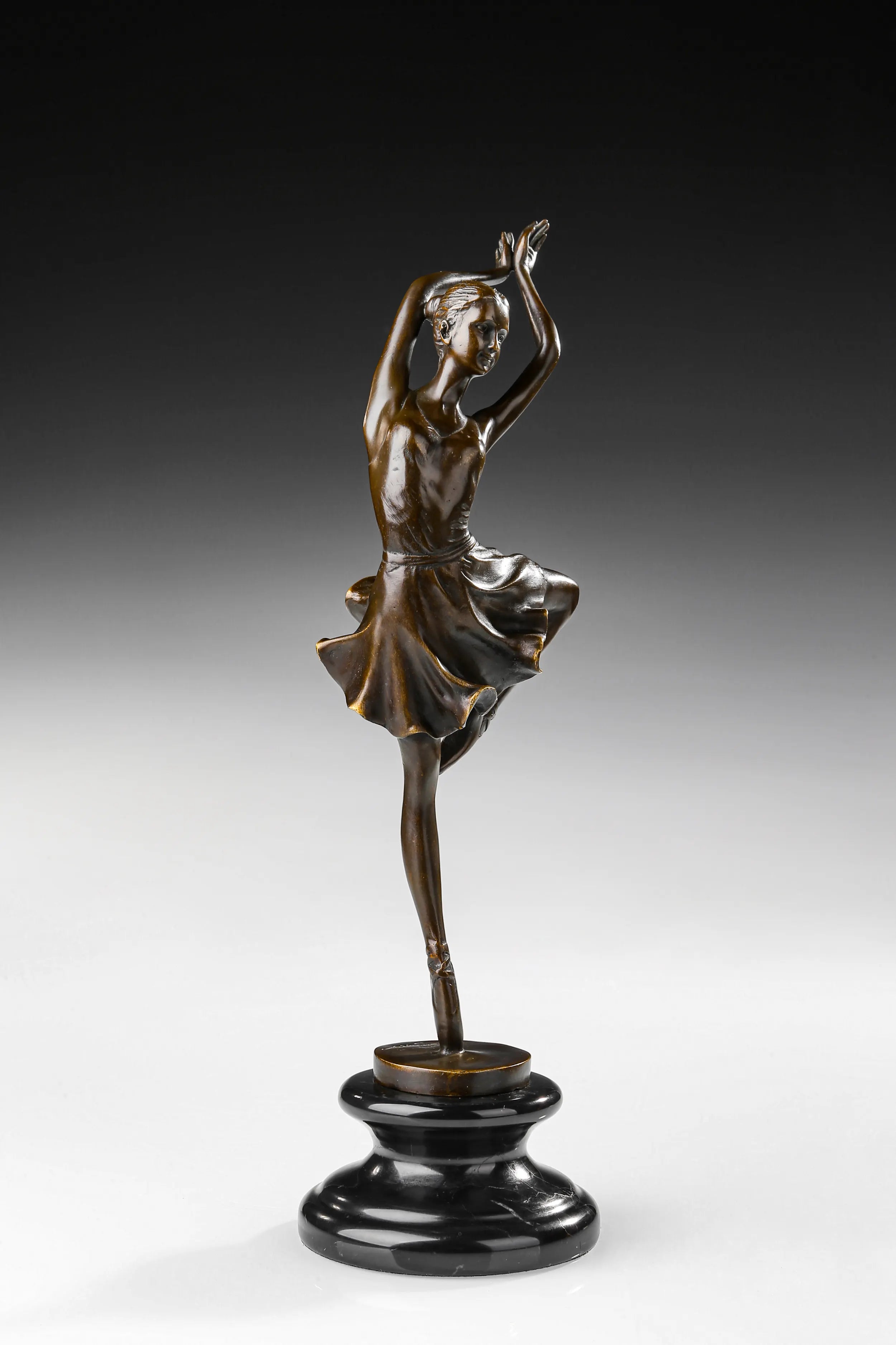 Three-quarter view of elegant bronze ballet dancer sculpture in a balancing pose