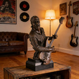 Realistic bronze rock guitarist bust with electric guitar, music themed sculpture on black marble base, edgy decor for recording studios.