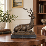 Seated bronze stag sculpture displayed as elegant wildlife decor in a refined home or office interior