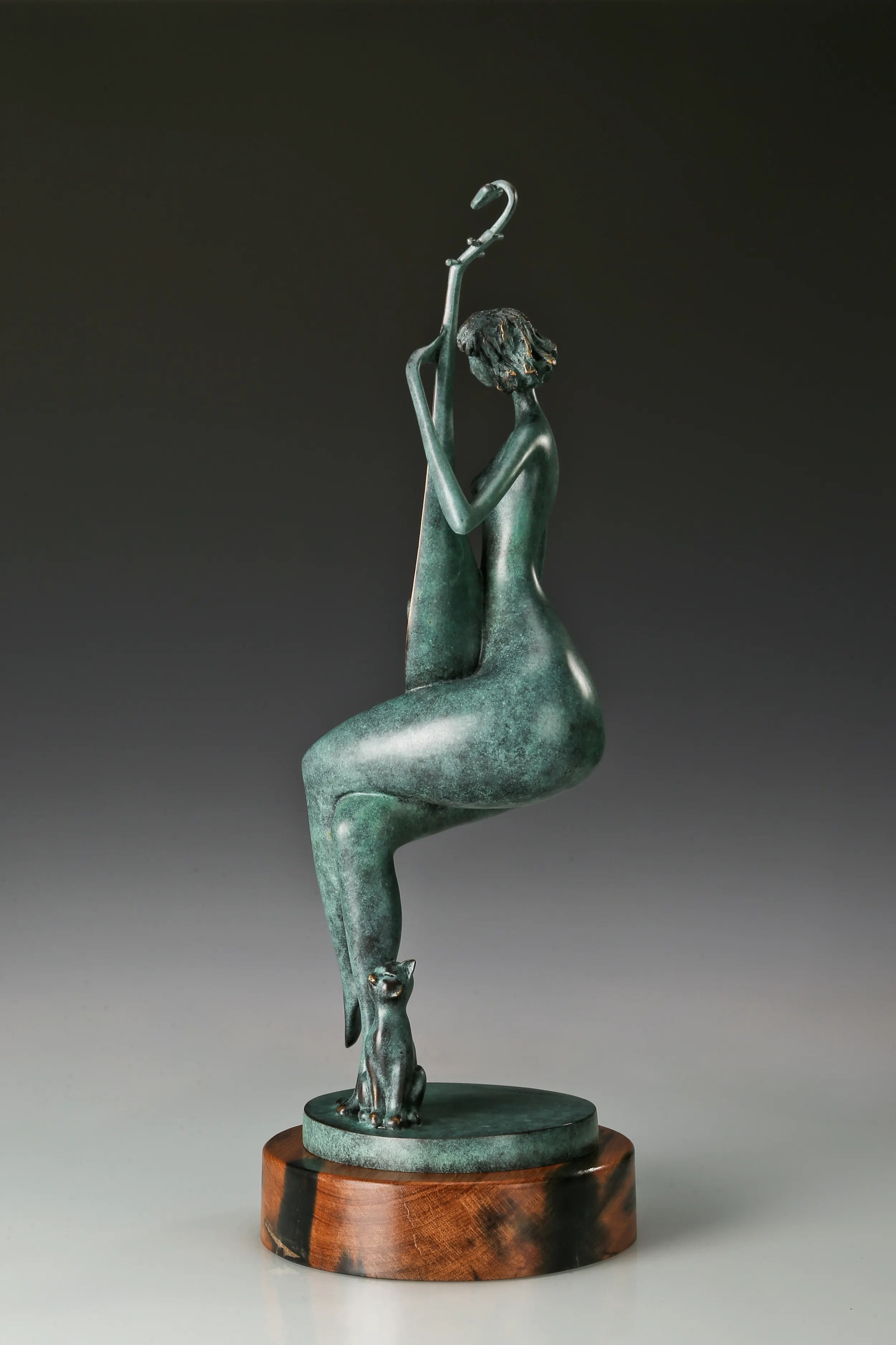Opposite side view of the seated female pipa player sculpture on a circular wooden base