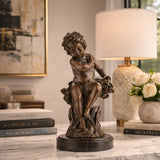 Exquisite bronze putto sculpture dreaming or sleeping, curly-haired cherub statue with flowers on round black marble base, loss wax casting classical fine art.