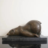 Sleeping polar bear bronze sculpture resting on a black marble base