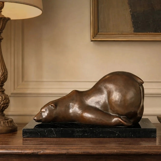 Sleeping polar bear bronze sculpture displayed in a warm modern interior
