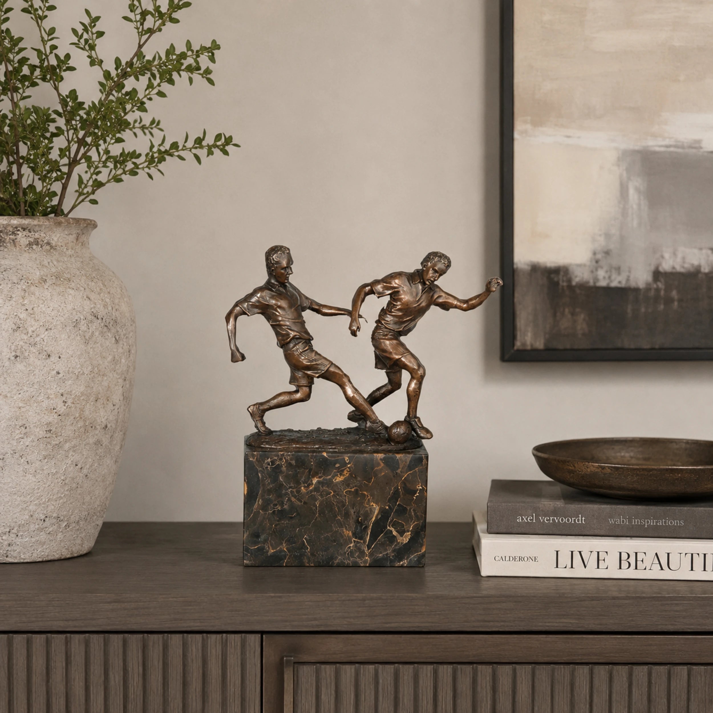 Soccer Players Duel Bronze Sculpture displayed in a modern interior