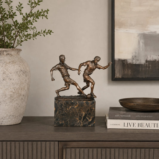 Soccer Players Duel Bronze Sculpture displayed in a modern interior
