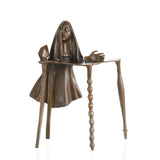 Surrealist bronze sculpture of female figure emerging from abstract table