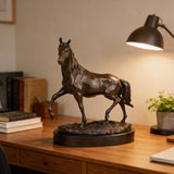 Lively trotting bronze horse sculpture with raised foreleg and turned head, realistic equestrian statue on round black marble base, loss wax casting fine art.