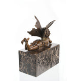 Whimsical bronze reclining fairy sculpture with butterfly wings on gold-veined marble base, magical fantasy art for bedroom decor.