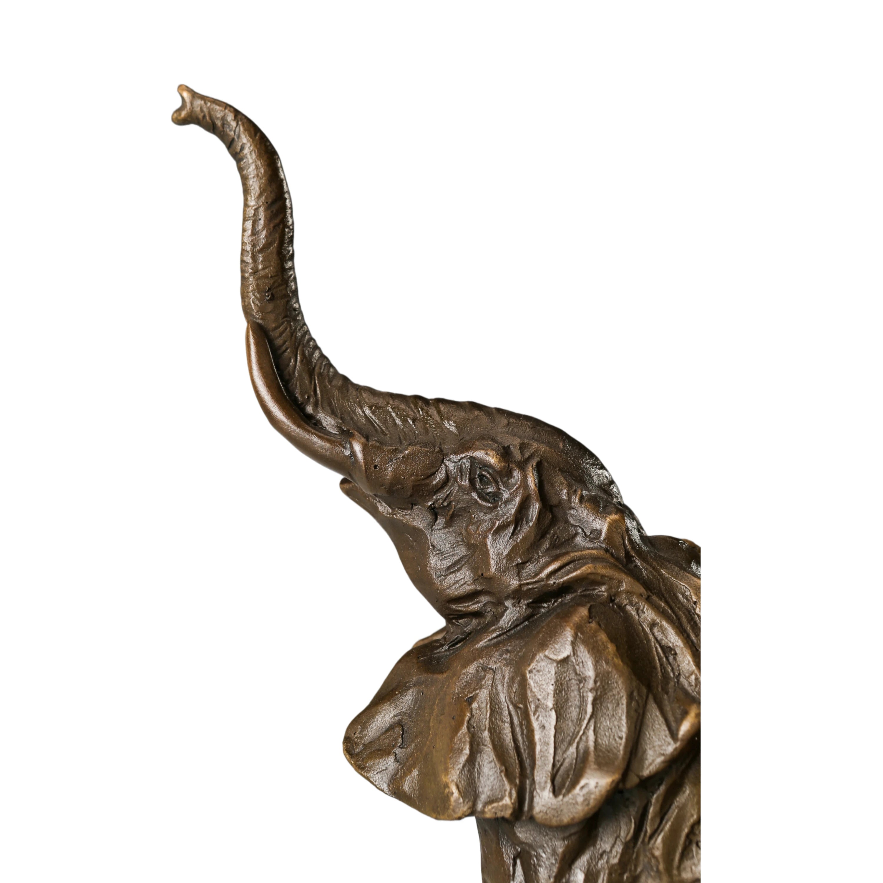 Playful elephant calf bronze sculpture with raised trunk and textured patina. A charming wildlife statue symbolizing joy, luck, and new beginnings.