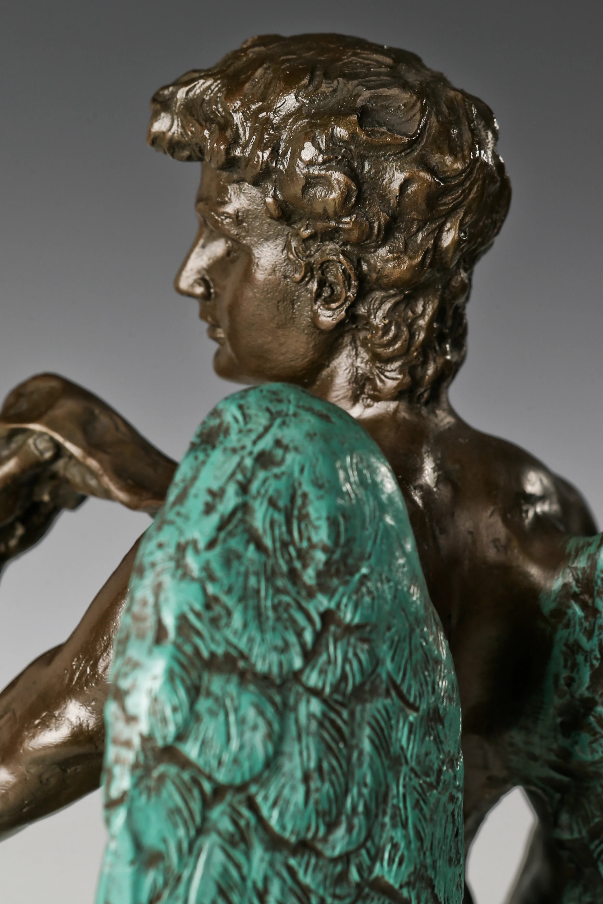 Close-up detail of handcrafted bronze male figure sculpture