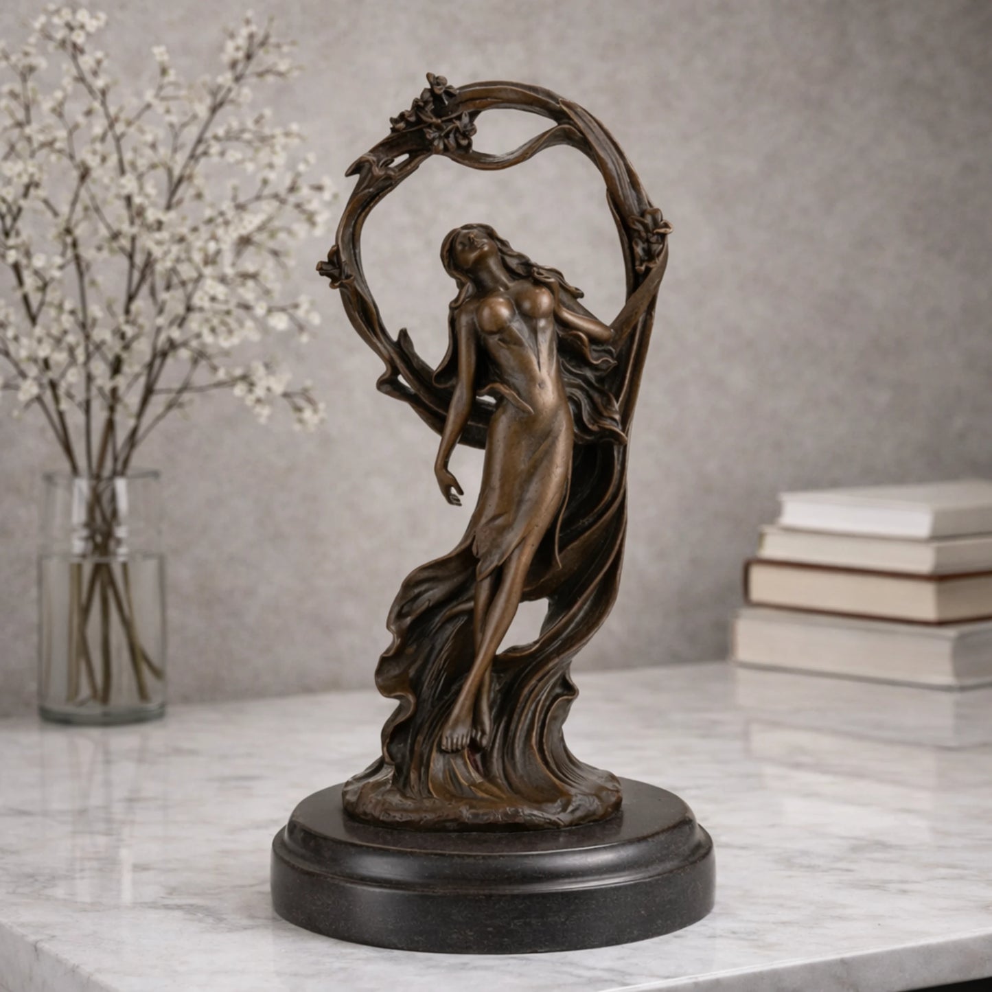 Art Nouveau bronze woman sculpture holding an orb, ethereal maiden statue with billowing gown and floral arch on black marble base, loss wax casting fine art.