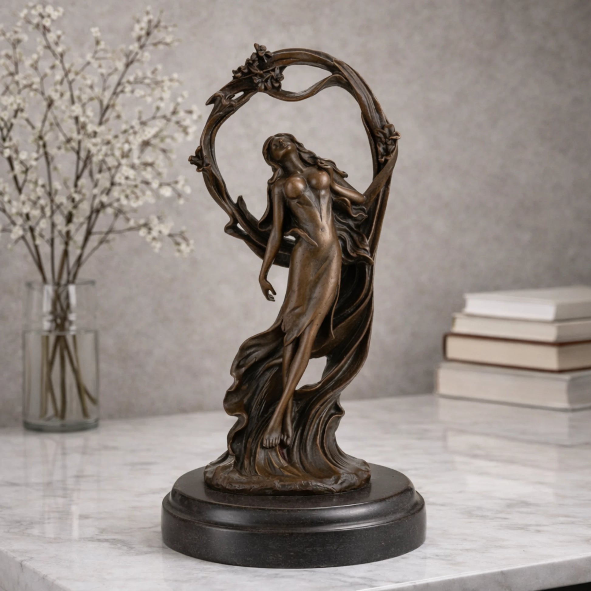 Art Nouveau bronze woman sculpture holding an orb, ethereal maiden statue with billowing gown and floral arch on black marble base, loss wax casting fine art.