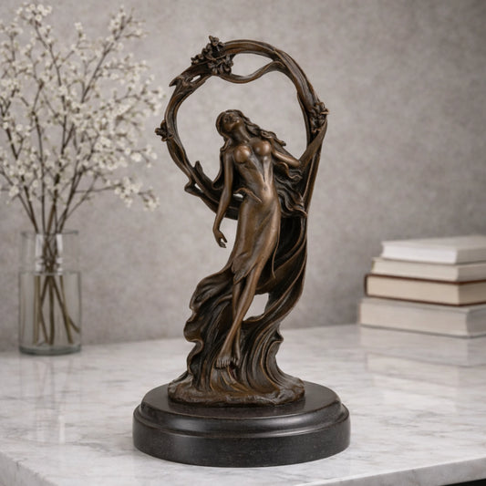 Art Nouveau bronze woman sculpture holding an orb, ethereal maiden statue with billowing gown and floral arch on black marble base, loss wax casting fine art.