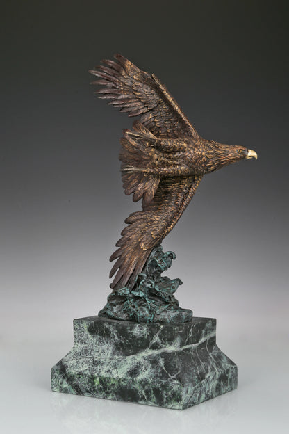 Bronze eagle sculpture with wings spread, capturing a powerful takeoff moment. A bold statue symbolizing strength, freedom, and ambition.