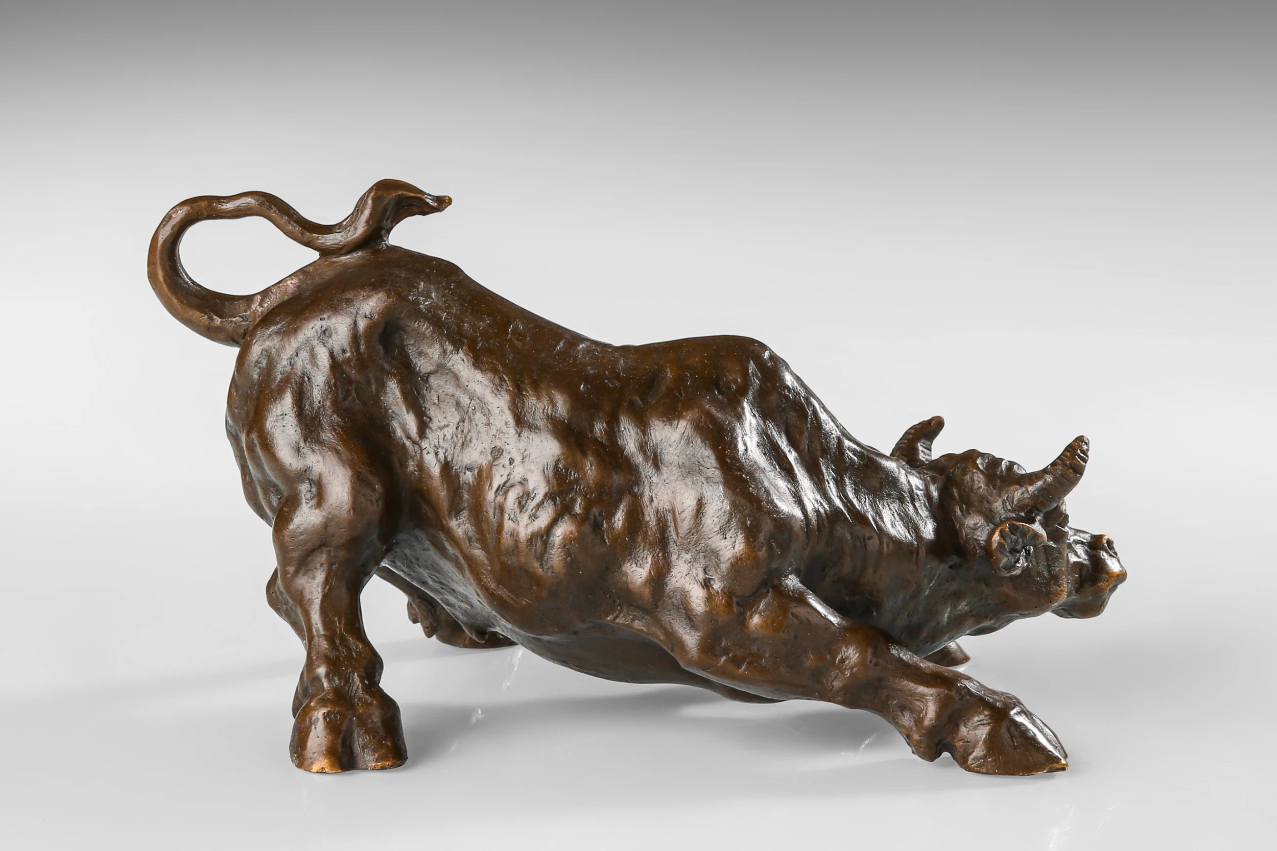 Wall Street charging bull bronze sculpture in a powerful pose, realistic bull market statue on black marble base, loss wax casting fine art.