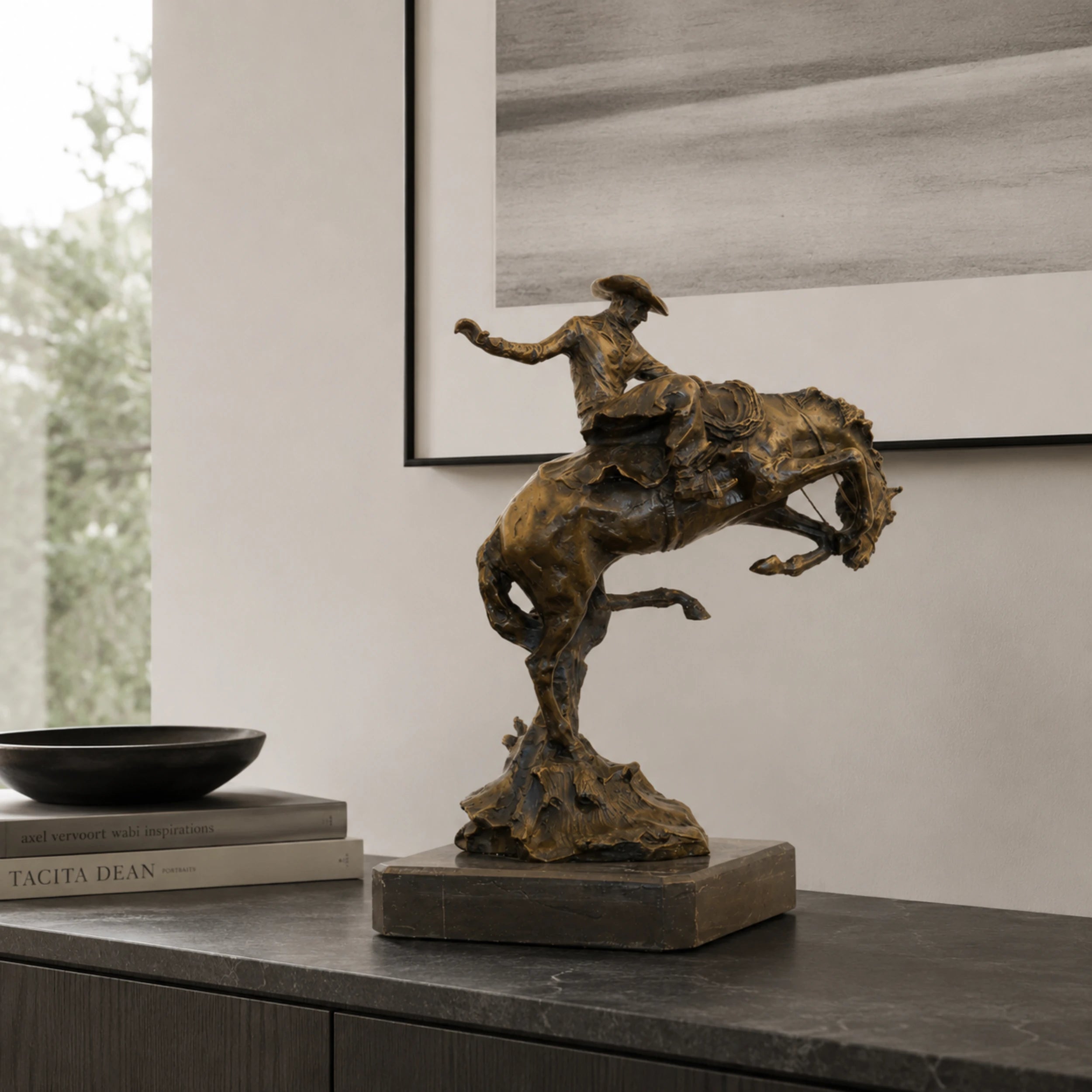 Bronze reproduction of Frederic Remington's Broncho Buster statue, cowboy riding a bucking horse on black marble base, loss wax casting fine art.