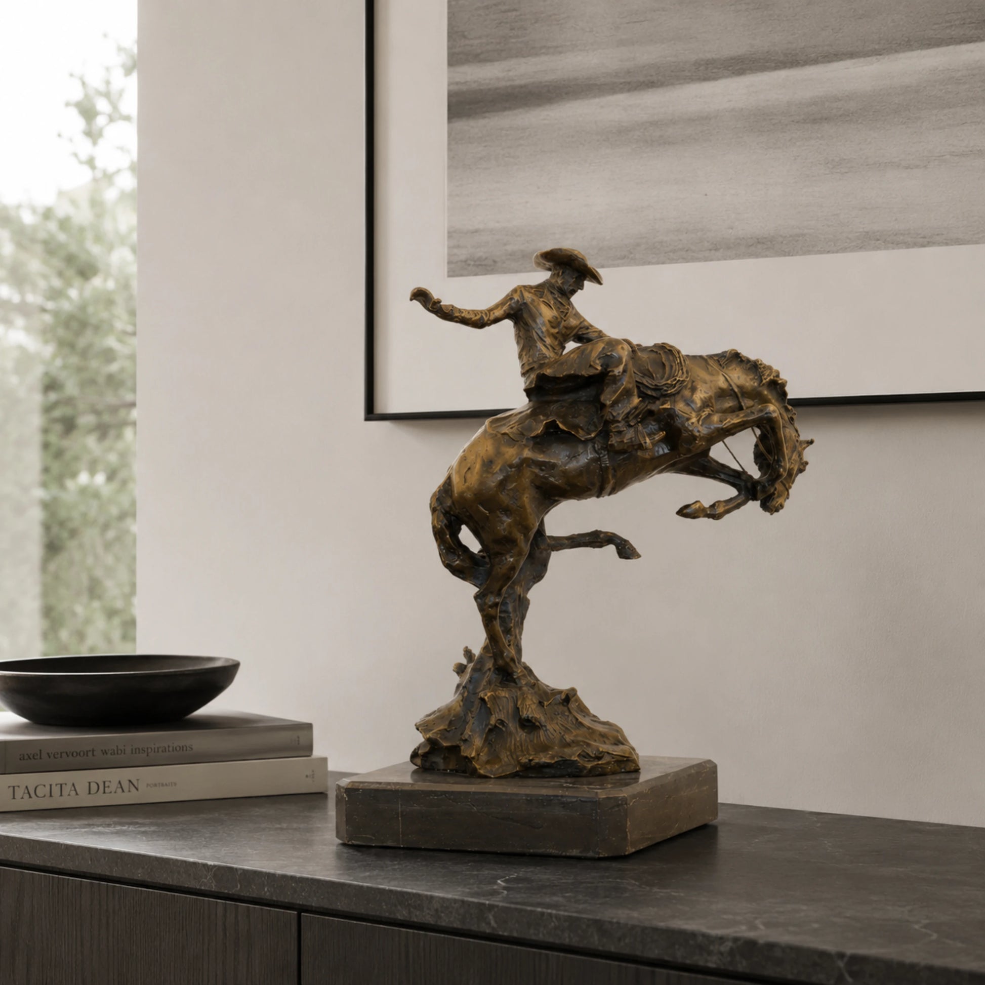 Bronze reproduction of Frederic Remington's Broncho Buster statue, cowboy riding a bucking horse on black marble base, loss wax casting fine art.