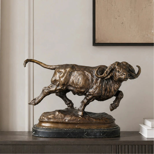 Realistic charging Cape buffalo bronze sculpture with warm brown patina, African wildlife animal statue on black marble base, loss wax casting fine art.
