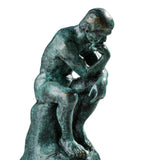 Profile of the Rodin-inspired Thinker sculpture in a contemplative seated pose