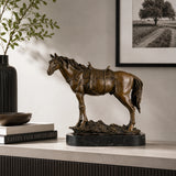 Saddled standing bronze horse sculpture with detailed tack and warm brown patina, realistic equestrian statue on black marble base, loss wax casting fine art.