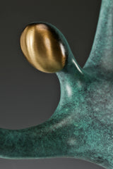 Close-up of the abstract bronze dancer's smooth gold-toned face