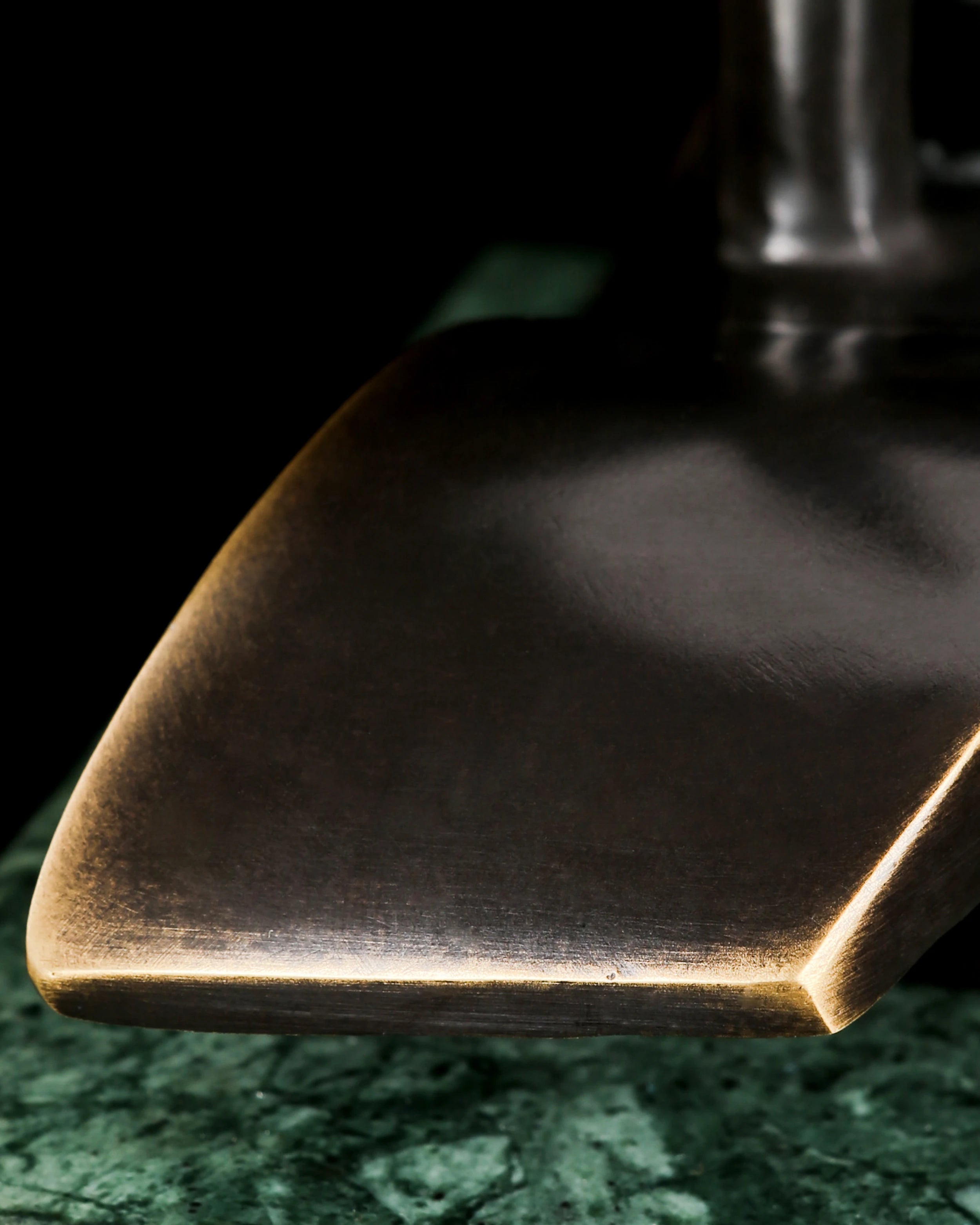 Close-up of abstract bronze sailboat hull with smooth flowing lines and warm patina