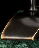 Close-up of abstract bronze sailboat hull with smooth flowing lines and warm patina