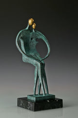 Three-quarter view of abstract bronze lovers statue on a polished black marble base