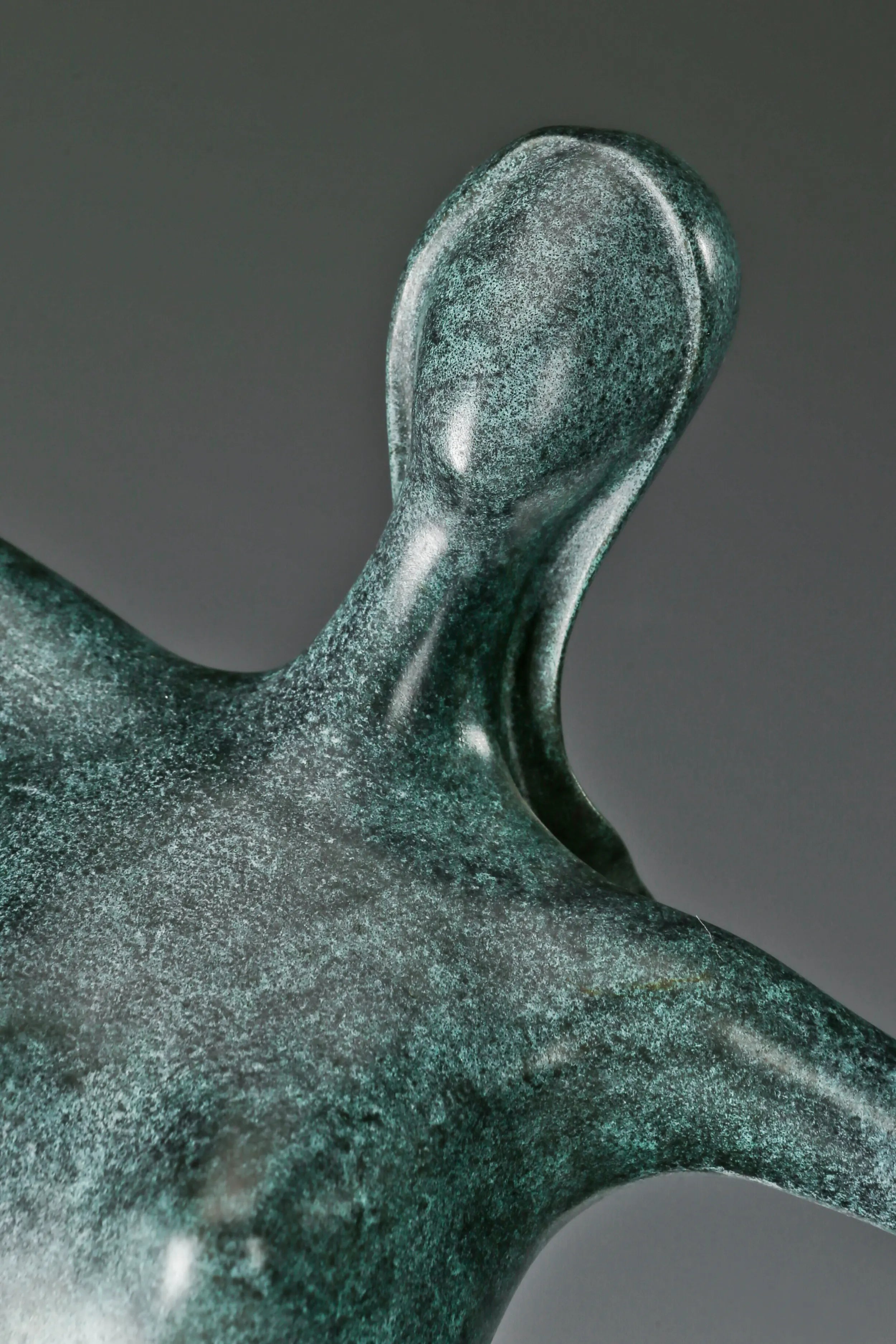 Close-up of abstract dancing woman bronze sculpture showing elongated arms and minimalist figure