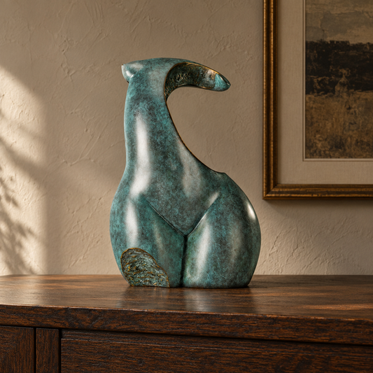 Abstract female torso bronze sculpture displayed in a minimalist modern interior with warm natural light