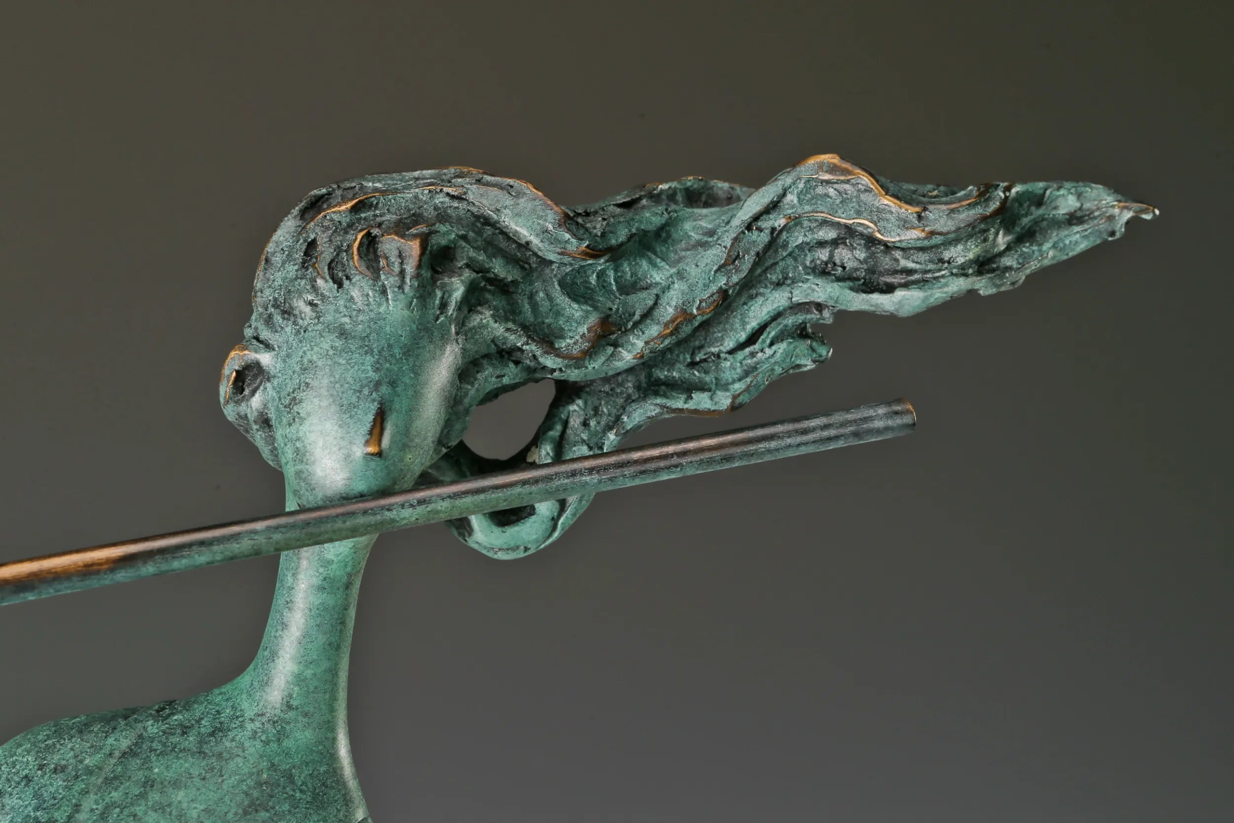 Close-up of the abstract woman's face, windswept hair, and horizontal flute