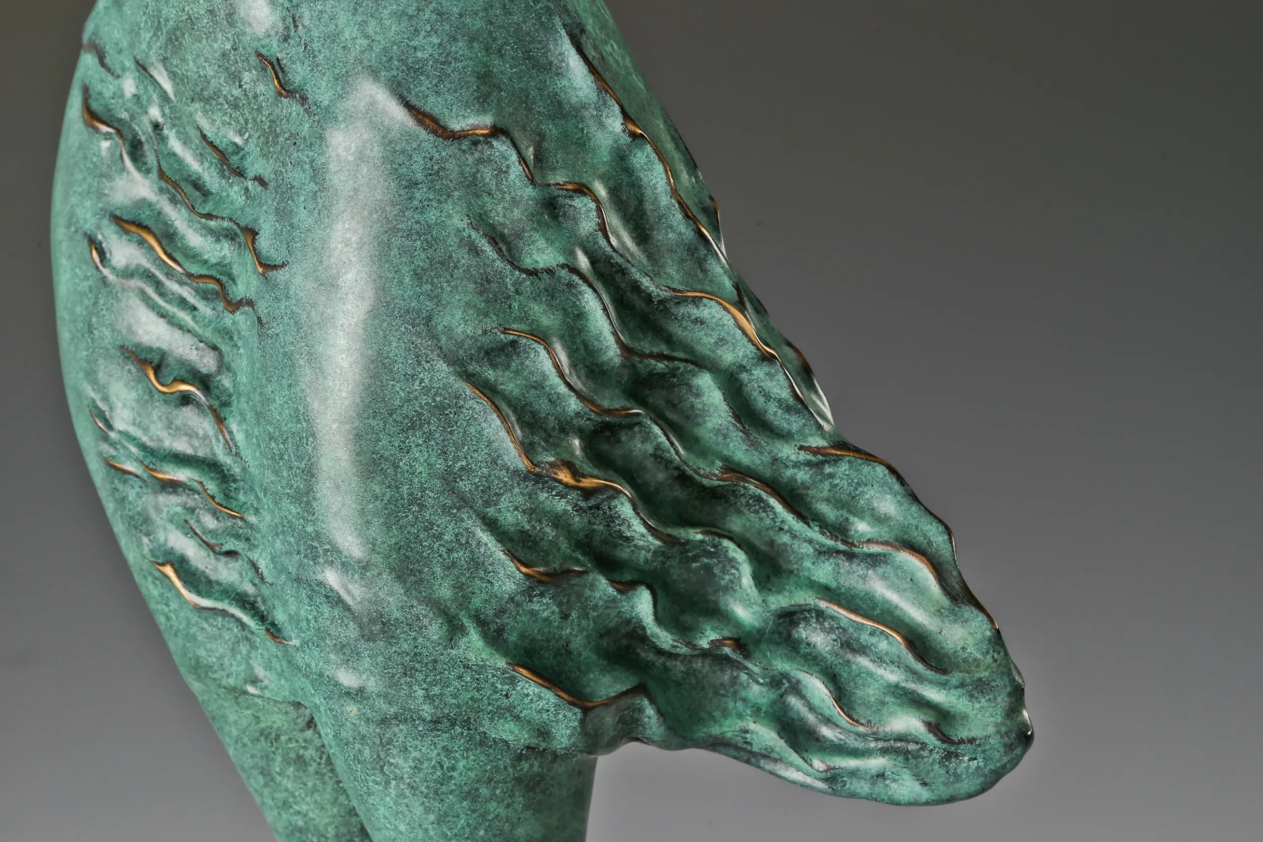 Detailed view of the flowing textured skirt with green patina and subtle golden highlights