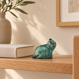 Abstract gazing cat bronze sculpture with green patina displayed in a modern home interior