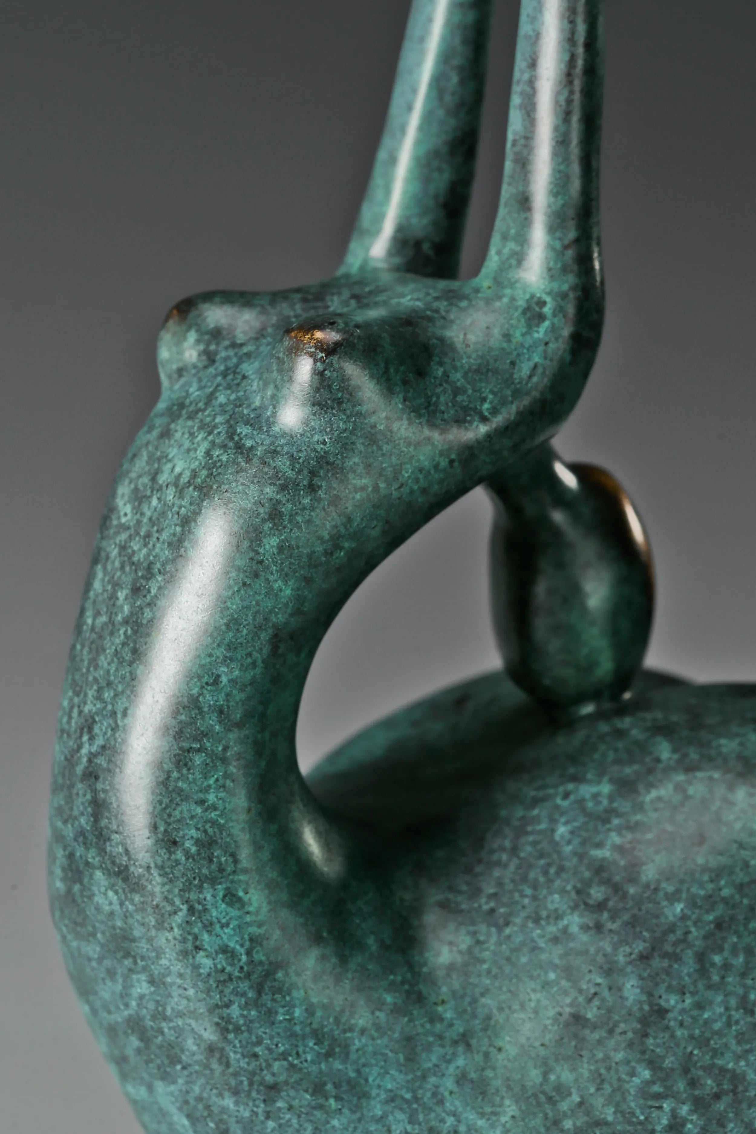 Close-up of the curved bronze body and raised arm of abstract gymnast statue