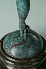 Detail of the gymnast sculpture's supporting leg and green patina above its black base