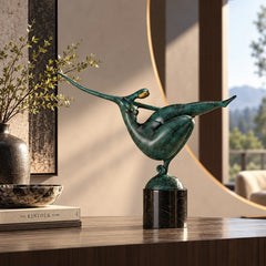 Abstract gymnastics bronze sculpture with an arched body and extended leg displayed in a modern home interior