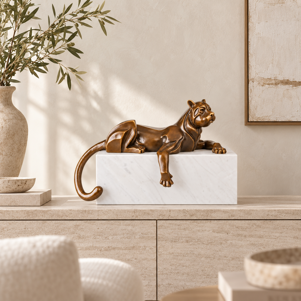 Abstract lying cat bronze sculpture displayed on a console table in a modern home interior