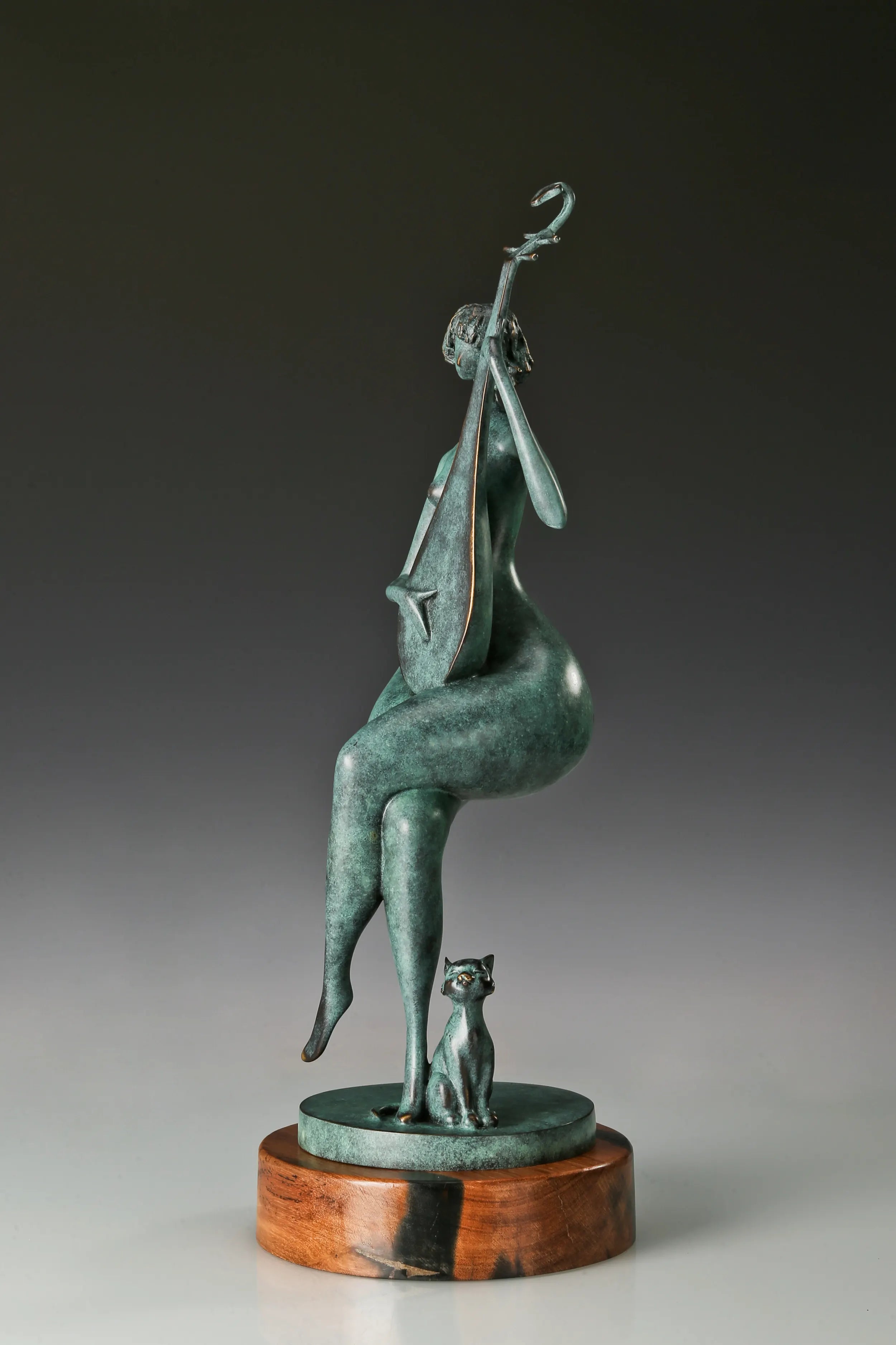 Side view of the abstract bronze pipa player showing the upright instrument and crossed legs