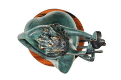 Top view of the seated female pipa player sculpture showing the instrument, hair, and round base